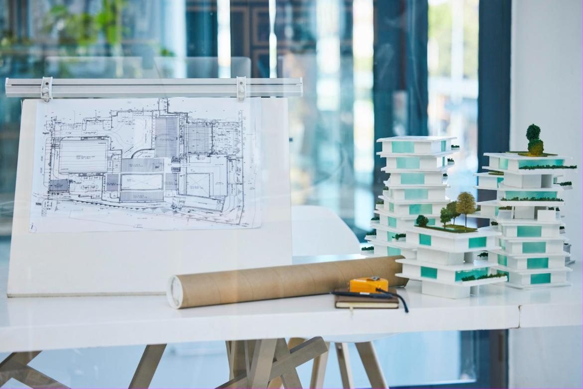 Plans and architectural models on a drafting table